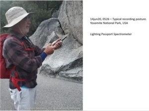 Photo of a man taking manual outdoor light spectrum measurements using a portable spectrum analyzer.