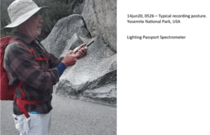 Photo of a man taking manual outdoor light spectrum measurements using a portable spectrum analyzer.