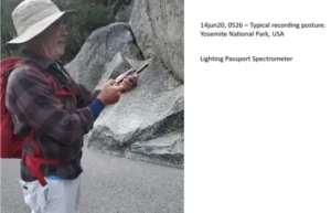 Photo of a man taking manual outdoor light spectrum measurements using a portable spectrum analyzer.