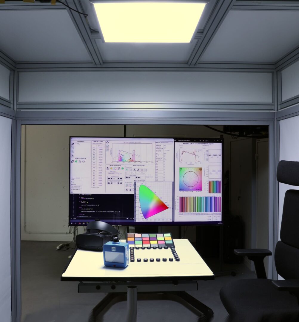 A light perception testing laboratory with color charts, CIE color space graphs being illuminated by Telelumen’s 24 LED channel light synthesizer. Human light perception is tested under various light levels and spectral qualities such as CRI and CCT parameters.