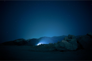 Starry night sky over rocky landscape.